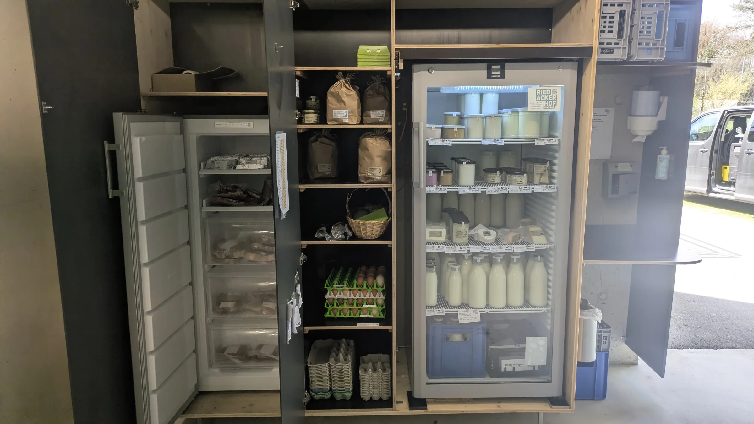 Holzschrank mit zwei K&uuml;hlschr&auml;nken, Milchflaschen, Joghurt und Mehl, die linke T&uuml;r steht offen